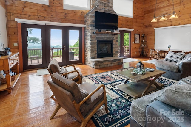 853 Granny Lewis Ln, Mars Hill, NC 28754 - living area featuring a high ceiling, french doors, wood walls, light wood-style floors, and a stone fireplace