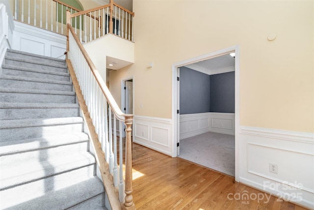 1002 Hollyhedge Ln, Indian Trail, NC 28079 - stairs with wood finished floors, wainscoting, a decorative wall, and a high ceiling