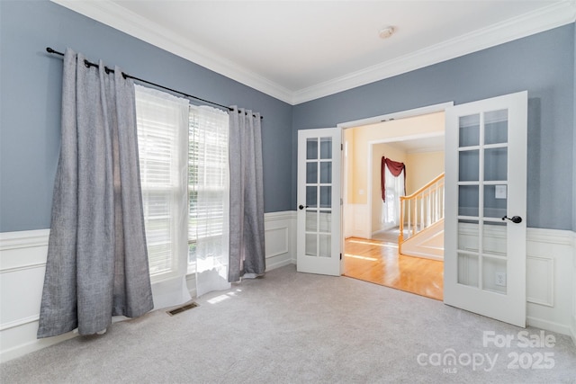 1002 Hollyhedge Ln, Indian Trail, NC 28079 - empty room featuring french doors, carpet floors, ornamental molding, wainscoting, and a smoke detector