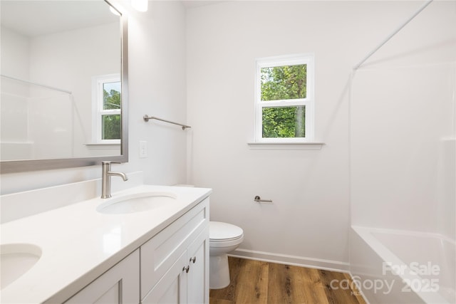 4226 Acorn St, Charlotte, NC 28205 - bathroom featuring double vanity, toilet, wood finished floors, baseboards, and bathing tub / shower combination