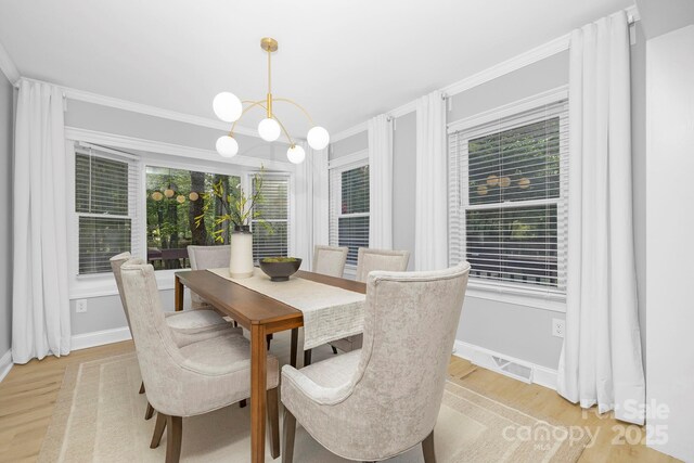 715 White Oaks Cir, Monroe, NC 28110 - dining area with light wood-style floors, crown molding, and a chandelier