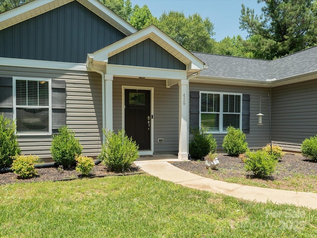 429 Summer Ridge Dr, Stanley, NC 28164 - view of exterior entry featuring a yard, roof with shingles, and board and batten siding