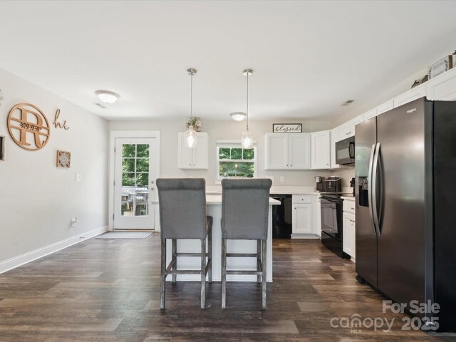 429 Summer Ridge Dr, Stanley, NC 28164 - kitchen with black appliances, light countertops, white cabinetry, a kitchen bar, and dark wood-style flooring