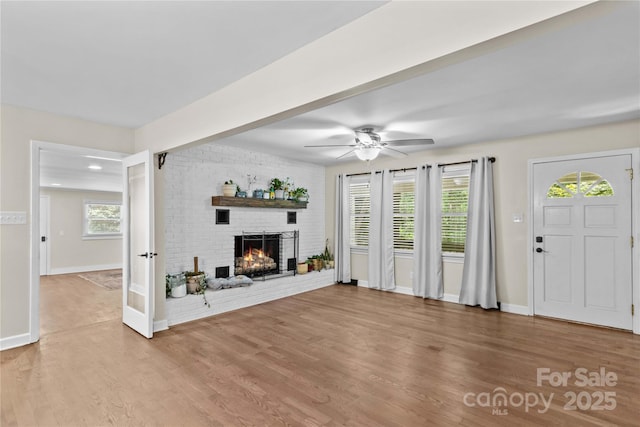 2229 Old Wilkesboro Rd, Statesville, NC 28625 - unfurnished living room featuring light wood-type flooring, healthy amount of natural light, baseboards, and a brick fireplace
