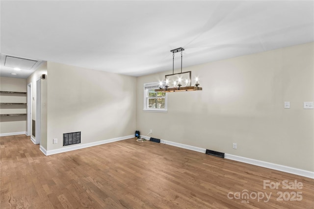 2229 Old Wilkesboro Rd, Statesville, NC 28625 - unfurnished dining area with wood finished floors, baseboards, a chandelier, and attic access