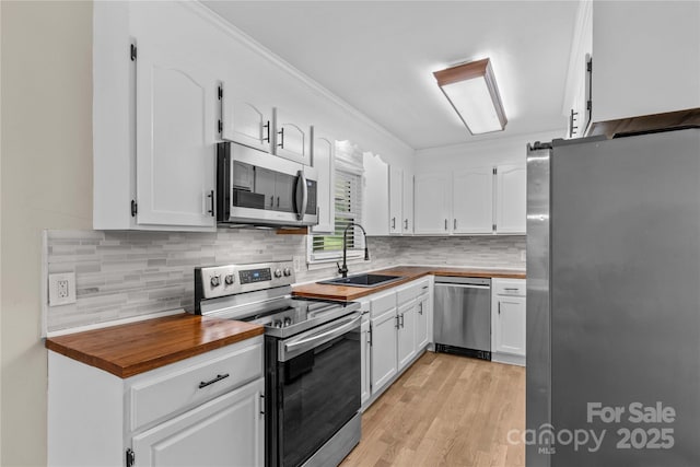 2229 Old Wilkesboro Rd, Statesville, NC 28625 - kitchen with appliances with stainless steel finishes, a sink, butcher block countertops, and white cabinetry