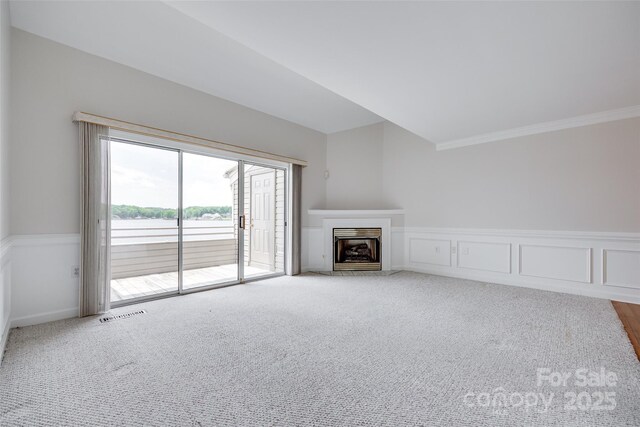 14053 Queens Harbor Rd, Charlotte, NC 28278 - unfurnished living room with carpet flooring, crown molding, a fireplace with flush hearth, and wainscoting