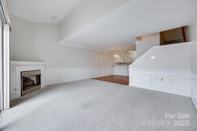 14053 Queens Harbor Rd, Charlotte, NC 28278 - unfurnished living room featuring carpet floors, a wainscoted wall, a fireplace, a decorative wall, and stairway