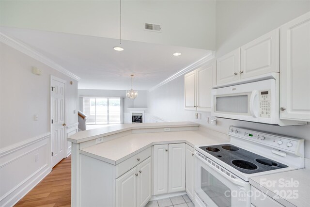 14053 Queens Harbor Rd, Charlotte, NC 28278 - kitchen featuring white appliances, a peninsula, ornamental molding, white cabinetry, and a chandelier