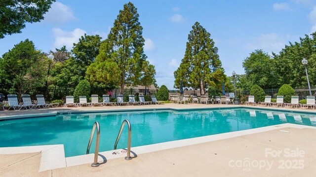 14053 Queens Harbor Rd, Charlotte, NC 28278 - community pool with a patio area and view of wooded area