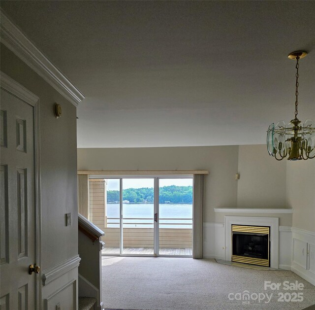 14053 Queens Harbor Rd, Charlotte, NC 28278 - unfurnished living room with carpet floors, a chandelier, a water view, a fireplace, and crown molding