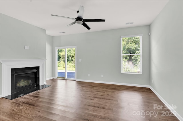 3207 Selwyn Landing Dr, Charlotte, NC 28215 - unfurnished living room featuring plenty of natural light, a ceiling fan, and wood finished floors