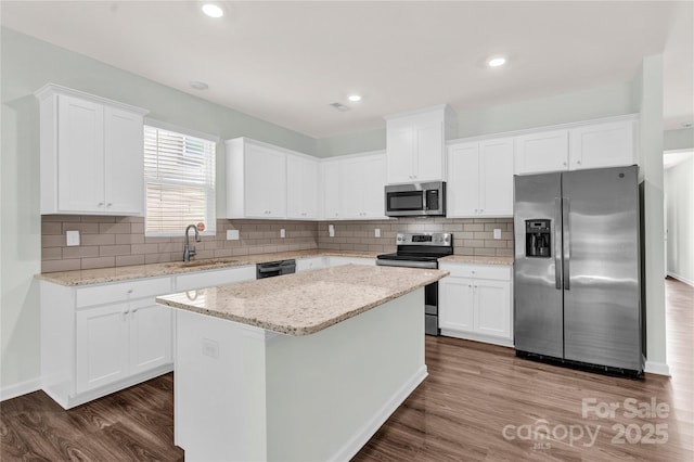 3207 Selwyn Landing Dr, Charlotte, NC 28215 - kitchen with appliances with stainless steel finishes, dark wood finished floors, white cabinetry, a center island, and recessed lighting