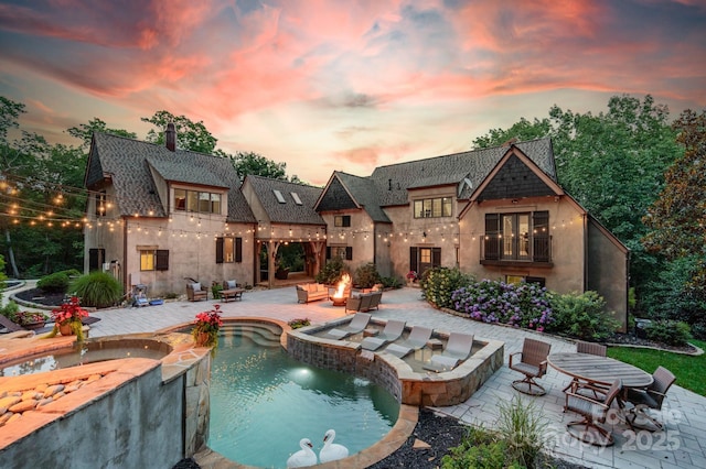 3587 Ridgetop Rd, Sherrills Ford, NC 28673 - back of property with stucco siding, a patio, an outdoor living space with a fire pit, a pool with connected hot tub, and a chimney