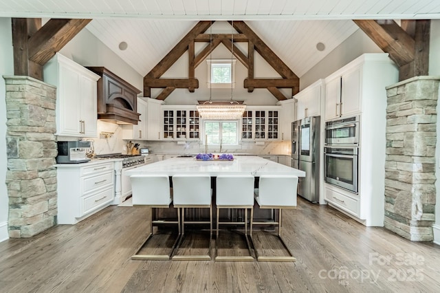 3587 Ridgetop Rd, Sherrills Ford, NC 28673 - kitchen with stainless steel appliances, a kitchen island, a breakfast bar area, high vaulted ceiling, and white cabinets