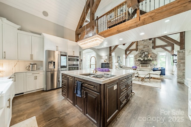 3587 Ridgetop Rd, Sherrills Ford, NC 28673 - kitchen with stainless steel appliances, open floor plan, a fireplace, white cabinets, and high vaulted ceiling