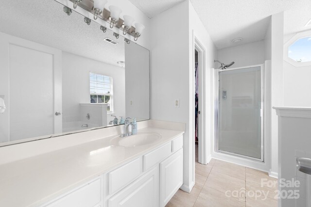 5104 Timbertop Ln, Charlotte, NC 28215 - bathroom with a stall shower, vanity, tile patterned flooring, a textured ceiling, and a walk in closet