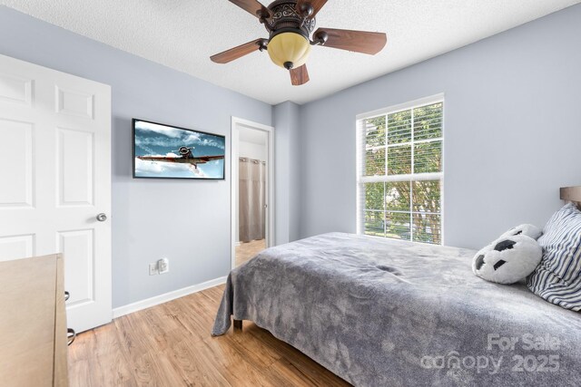 5104 Timbertop Ln, Charlotte, NC 28215 - bedroom featuring light wood-style floors, a ceiling fan, and a textured ceiling