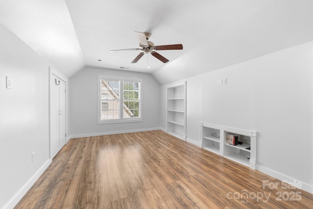 5104 Timbertop Ln, Charlotte, NC 28215 - bonus room featuring built in shelves, vaulted ceiling, a ceiling fan, and wood finished floors