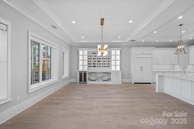 19329 Watermark Dr Unit 422, Cornelius, NC 28031 - unfurnished dining area featuring a chandelier, healthy amount of natural light, a tray ceiling, light wood-style floors, and ornamental molding