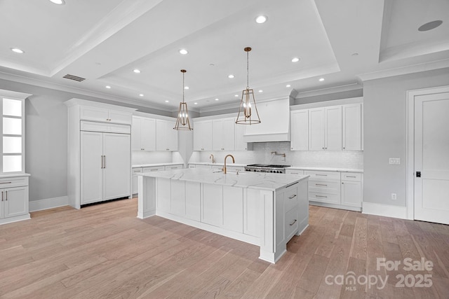19329 Watermark Dr Unit 422, Cornelius, NC 28031 - kitchen featuring paneled refrigerator, custom exhaust hood, light wood-style floors, crown molding, and a large island