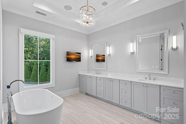 19329 Watermark Dr Unit 422, Cornelius, NC 28031 - bathroom featuring double vanity, a freestanding bath, a chandelier, and a tray ceiling