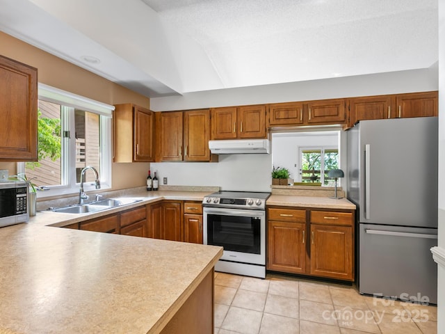 305 Piney Mountain Dr Unit B3, Asheville, NC 28805 - kitchen featuring appliances with stainless steel finishes, under cabinet range hood, light countertops, brown cabinetry, and light tile patterned flooring