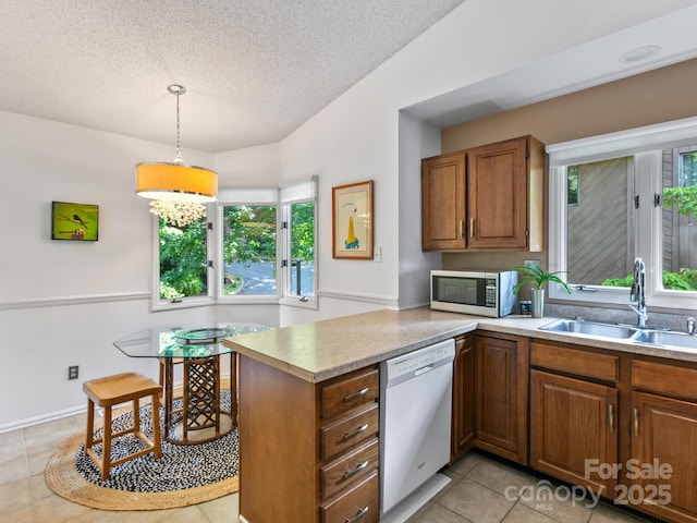 305 Piney Mountain Dr Unit B3, Asheville, NC 28805 - kitchen featuring white dishwasher, stainless steel microwave, a peninsula, brown cabinets, and light tile patterned floors
