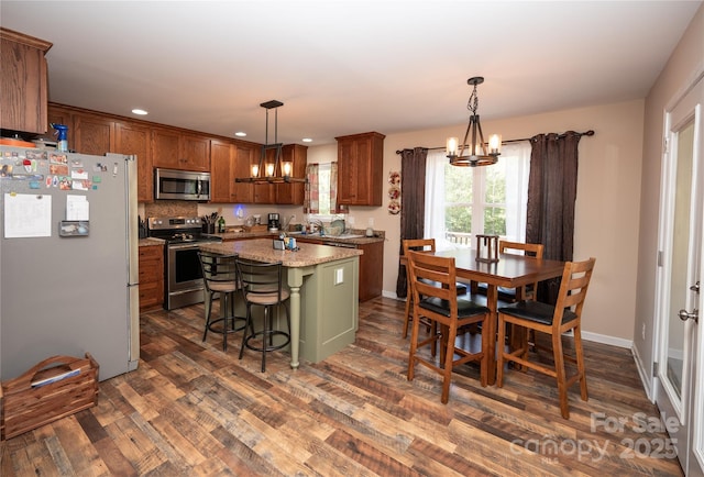 3330 Clinzo Feemster Rd, Hickory Grove, SC 29717 - kitchen with stainless steel appliances, a chandelier, a center island, dark wood-style floors, and brown cabinets