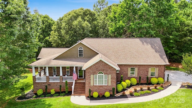 234 Rivercliff Dr, Stony Point, NC 28678 - view of front of home with covered porch, a front yard, a shingled roof, and brick siding