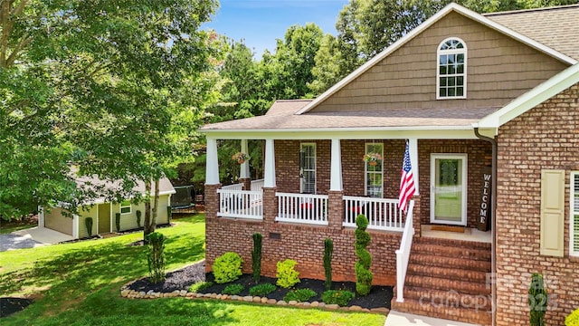 234 Rivercliff Dr, Stony Point, NC 28678 - view of front of house with a porch, a front yard, brick siding, and an outbuilding