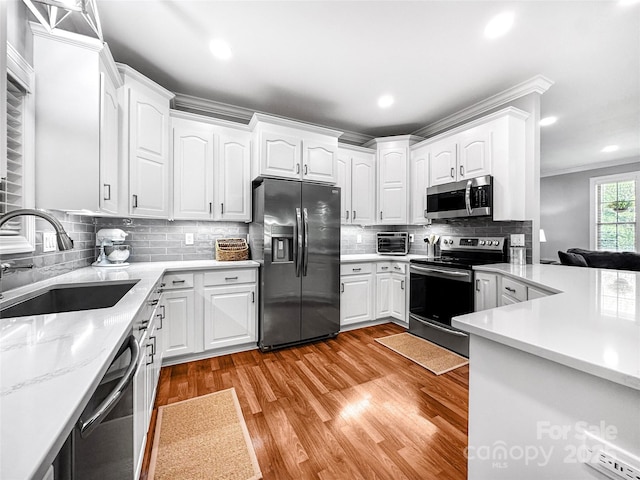 234 Rivercliff Dr, Stony Point, NC 28678 - kitchen with appliances with stainless steel finishes, light wood-style floors, white cabinetry, ornamental molding, and recessed lighting