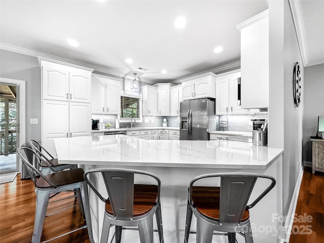 234 Rivercliff Dr, Stony Point, NC 28678 - kitchen featuring stainless steel appliances, crown molding, a breakfast bar, white cabinets, and recessed lighting