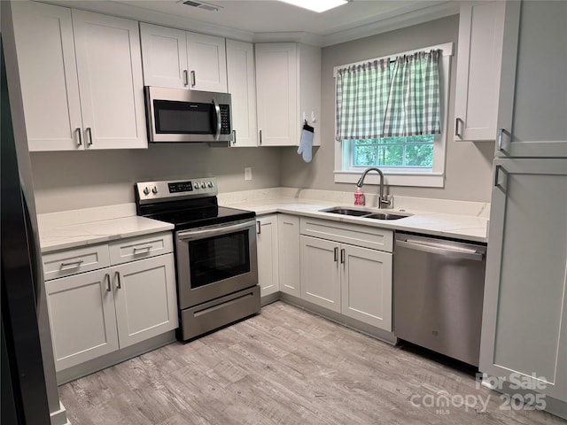 232 Harmony Hills Dr, Catawba, SC 29704 - kitchen featuring stainless steel appliances, light stone countertops, light wood-style floors, white cabinetry, and ornamental molding