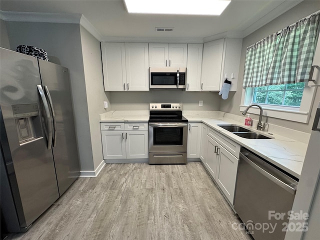232 Harmony Hills Dr, Catawba, SC 29704 - kitchen featuring stainless steel appliances, light wood-style floors, ornamental molding, white cabinets, and light stone countertops