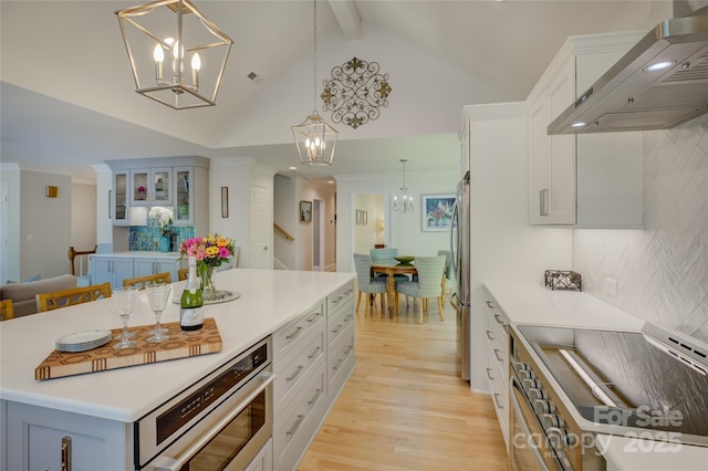 18205 Royal Oak Rd, Charlotte, NC 28278 - kitchen with wall chimney exhaust hood, a chandelier, light wood-style flooring, backsplash, and decorative light fixtures