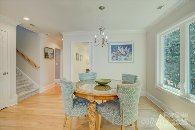 18205 Royal Oak Rd, Charlotte, NC 28278 - dining room featuring plenty of natural light, stairway, a chandelier, light wood-type flooring, and ornamental molding