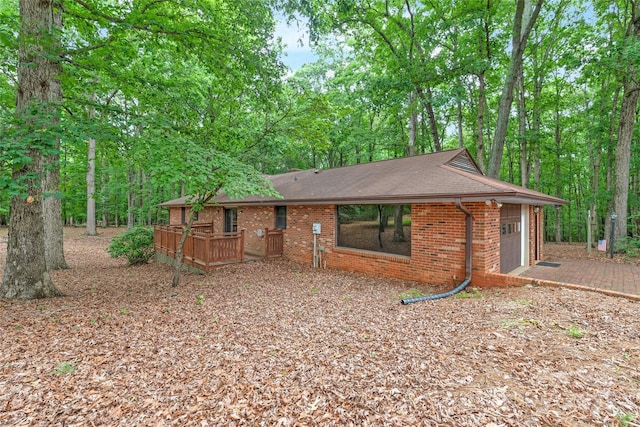3985 Well Rd, Mint Hill, NC 28227 - back of house featuring an attached garage, brick siding, roof with shingles, and a deck