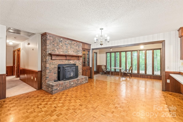 3985 Well Rd, Mint Hill, NC 28227 - unfurnished living room with wainscoting, a textured ceiling, wood walls, and a chandelier