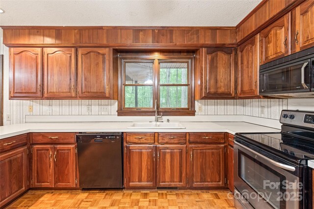 3985 Well Rd, Mint Hill, NC 28227 - kitchen with black appliances, a sink, light countertops, a textured ceiling, and brown cabinets