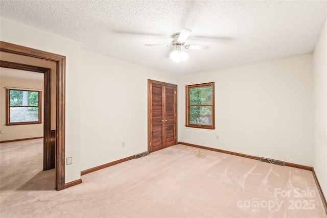 3985 Well Rd, Mint Hill, NC 28227 - unfurnished bedroom featuring light carpet, baseboards, a closet, a ceiling fan, and a textured ceiling