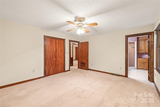 3985 Well Rd, Mint Hill, NC 28227 - unfurnished bedroom featuring light carpet, baseboards, ensuite bathroom, and a textured ceiling