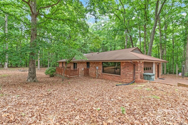 3985 Well Rd, Mint Hill, NC 28227 - view of front of home featuring a garage, brick siding, a deck, and roof with shingles