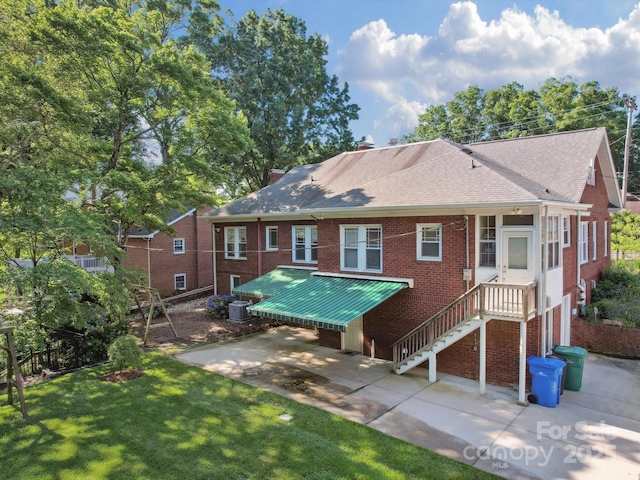 729 Montgomery Ave, Albemarle, NC 28001 - rear view of house featuring brick siding, roof with shingles, central AC, a yard, and a patio