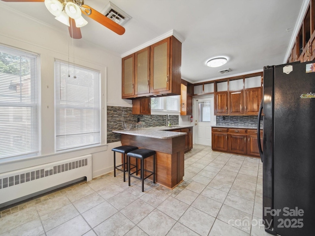 729 Montgomery Ave, Albemarle, NC 28001 - kitchen featuring freestanding refrigerator, radiator heating unit, a peninsula, a sink, and decorative backsplash
