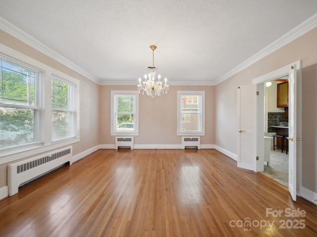 729 Montgomery Ave, Albemarle, NC 28001 - unfurnished dining area featuring radiator, a chandelier, light wood finished floors, and ornamental molding