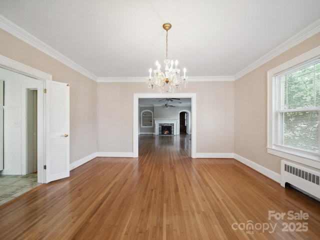 729 Montgomery Ave, Albemarle, NC 28001 - empty room featuring radiator heating unit, a chandelier, wood finished floors, ornamental molding, and baseboards