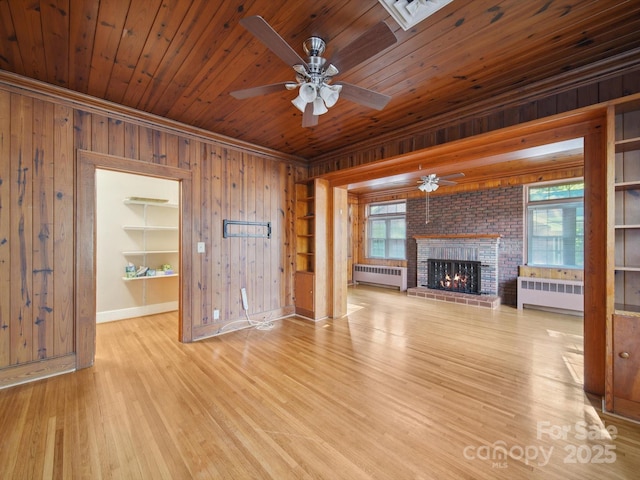729 Montgomery Ave, Albemarle, NC 28001 - unfurnished living room featuring radiator, wood walls, a ceiling fan, baseboards, and wooden ceiling
