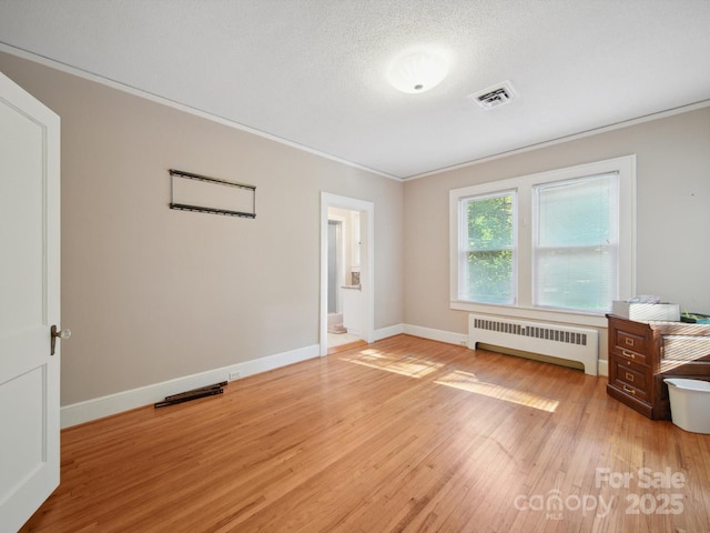 729 Montgomery Ave, Albemarle, NC 28001 - unfurnished room with radiator, ornamental molding, light wood-style floors, baseboards, and a textured ceiling