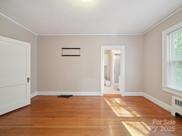 729 Montgomery Ave, Albemarle, NC 28001 - empty room featuring radiator heating unit, crown molding, light wood-type flooring, and baseboards